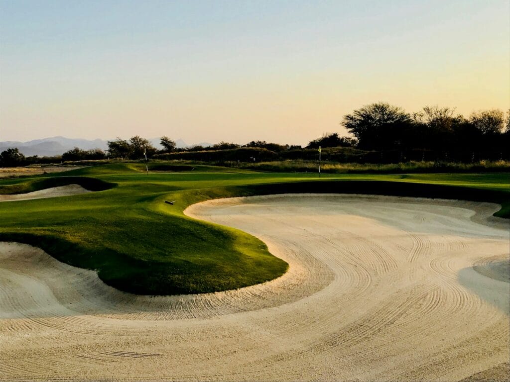 Desert golf course bunker and green with mountain backdrop, typical of premium Las Vegas-area courses for trade show attendees