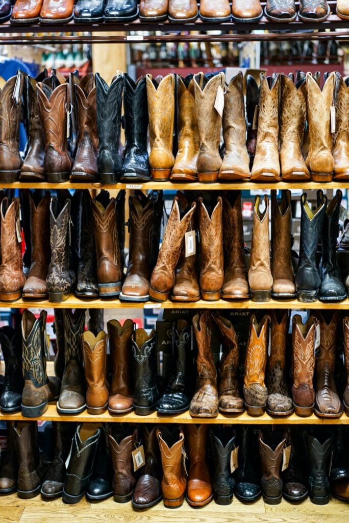 Rows of cowboy boots on display at a western vendor stall, like those at Cowboy Christmas, the free NFR gift show at the Las Vegas Convention Center