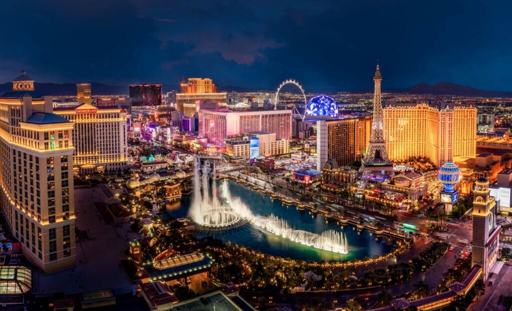 Las Vegas Strip aerial view at night featuring Bellagio fountains, Caesars Palace, Paris Las Vegas and Sphere - Credit LVCVA