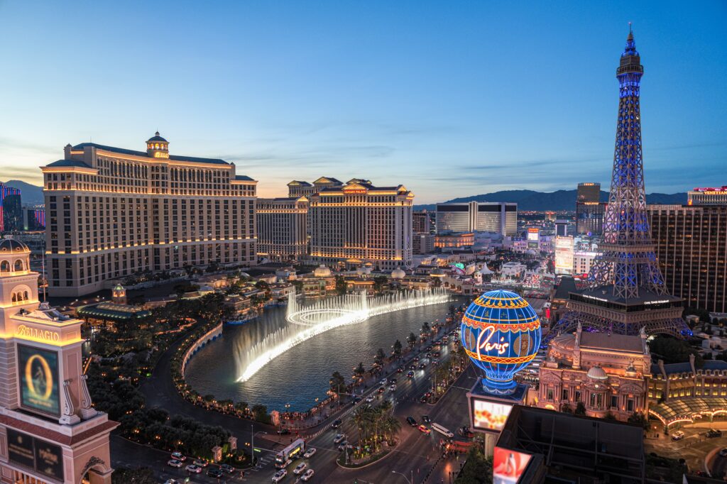 Bellagio fountains and the Paris Las Vegas balloon at dusk on the Strip
